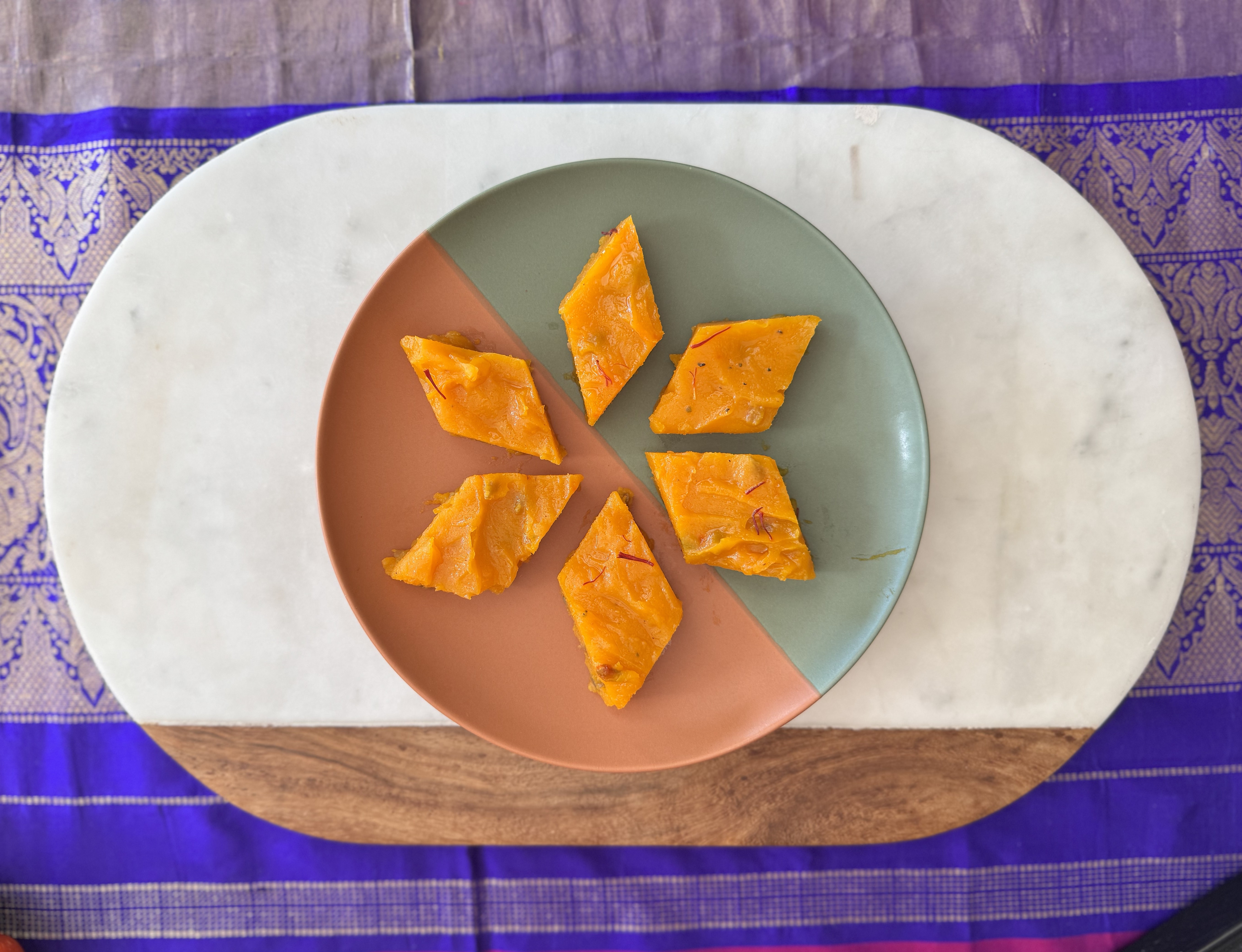 Image of pumpkin halwa served in pieces on a plate, a vegan, gluten-free, and dairy-free Indian dessert made with pumpkin.